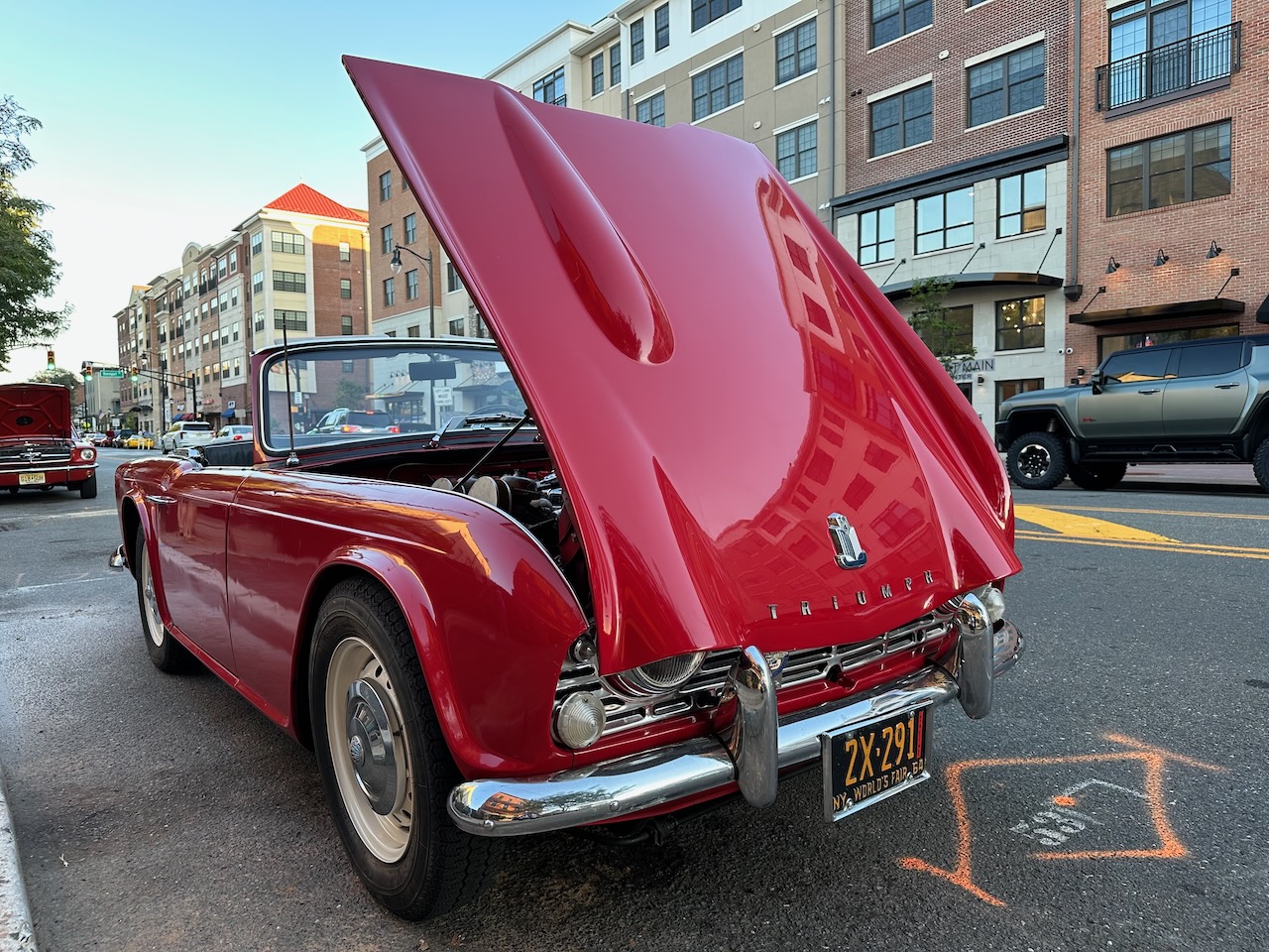 Red Triumph TR-4A convertible with hood up. 