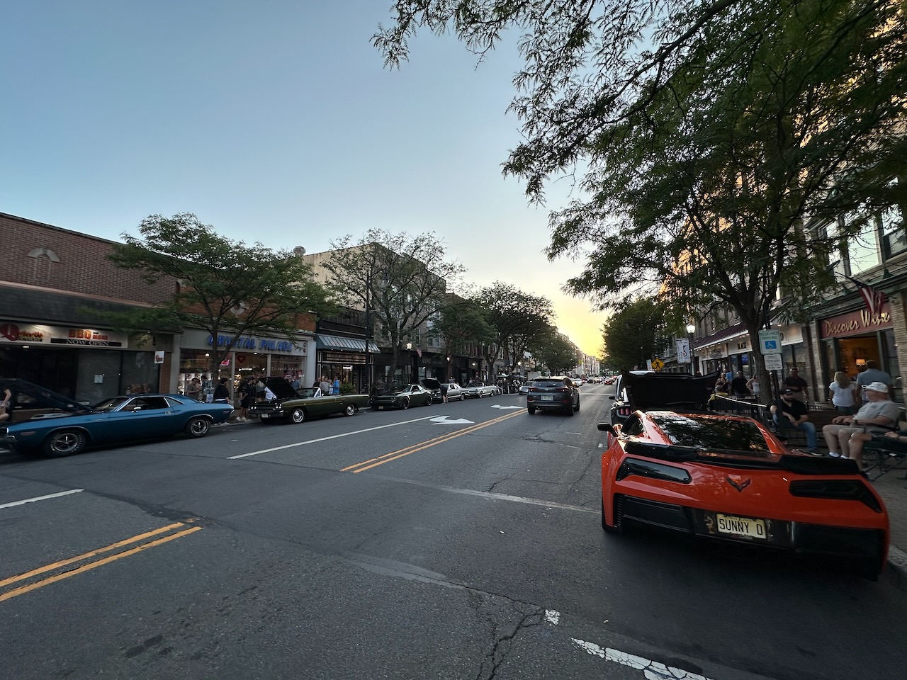 View of Main Street in Somerville at dusk, with classic cars on both sides of the road.