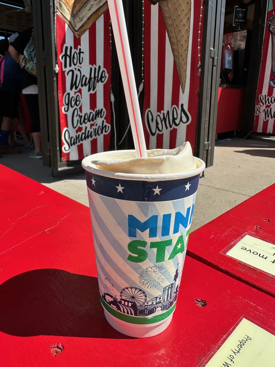 Milkshake in paper cup that says MINNESOTA STATE FAIR on sides.