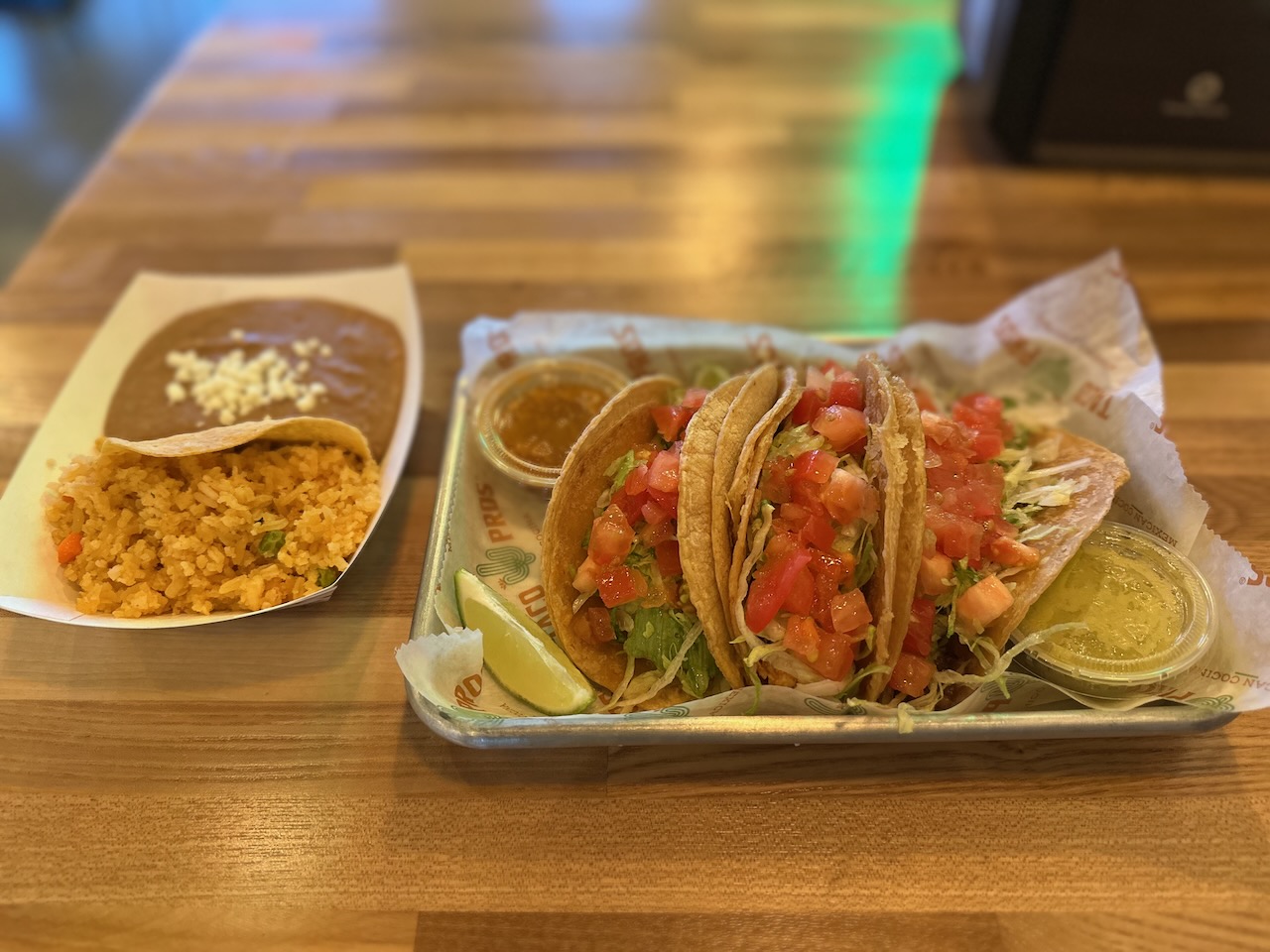 Tacos on platter with side of rice and beans.