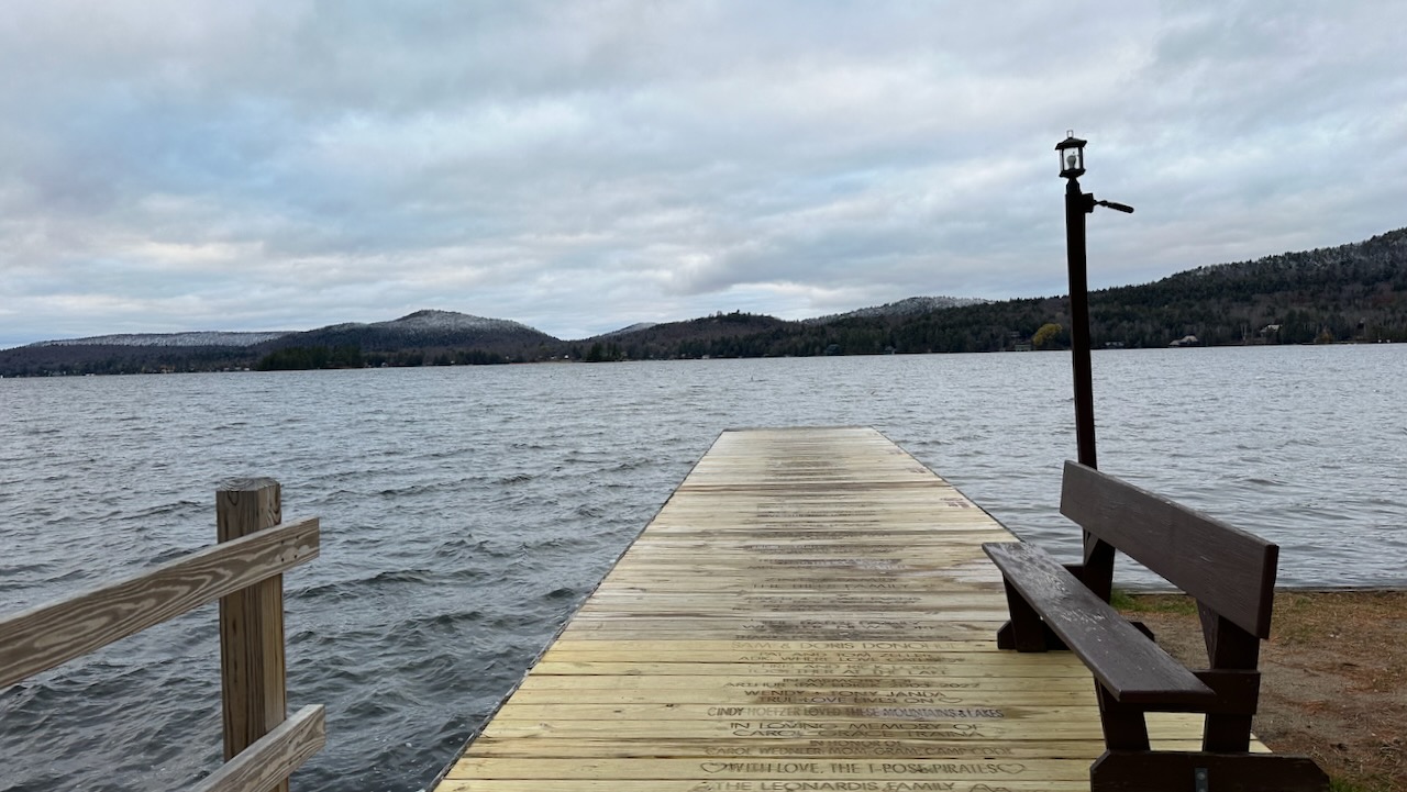 View of dock with Fourth Lake and mountains in background.