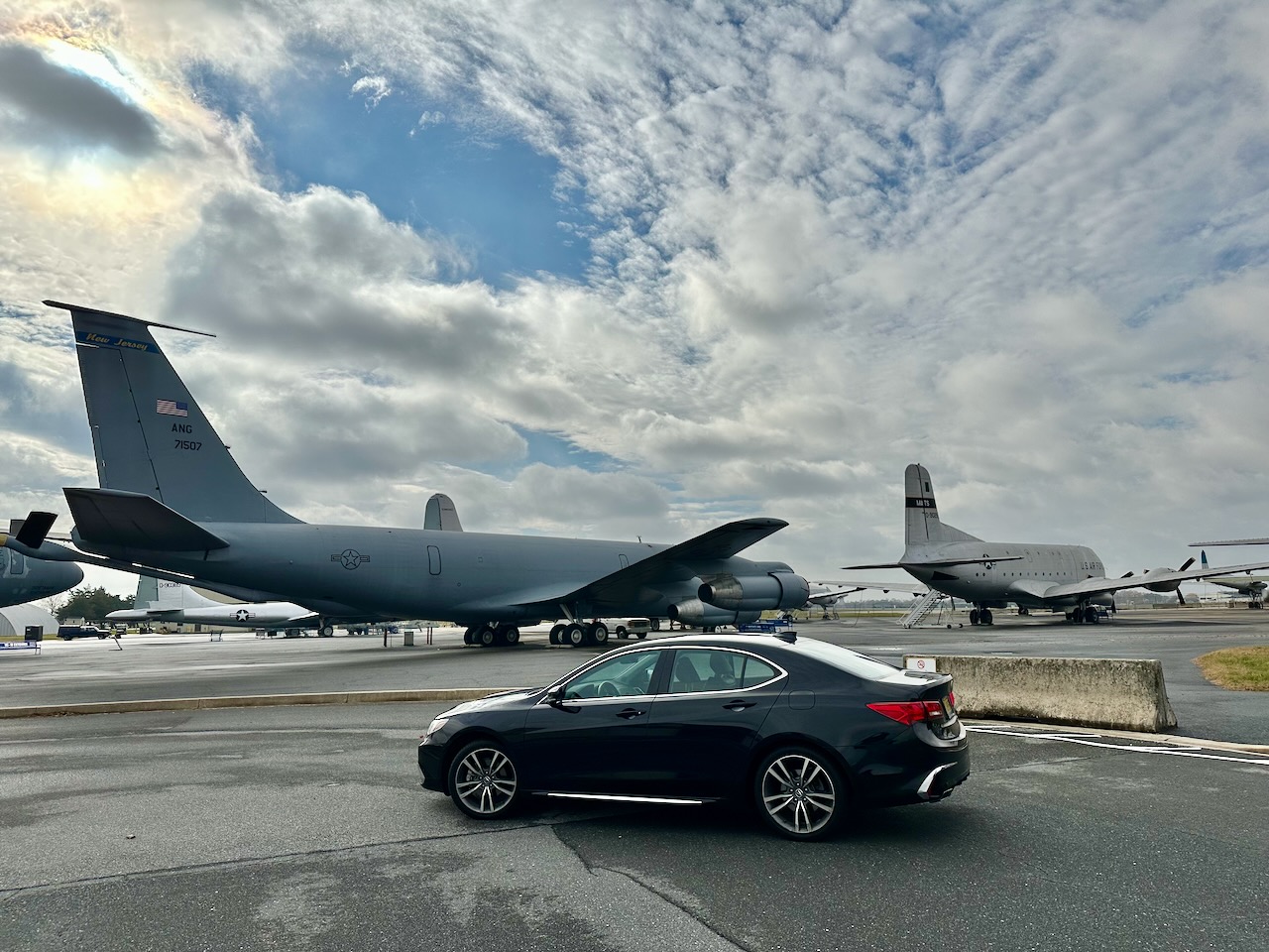 2020 Acura TLX parked near tarmac, with cargo planes in background.