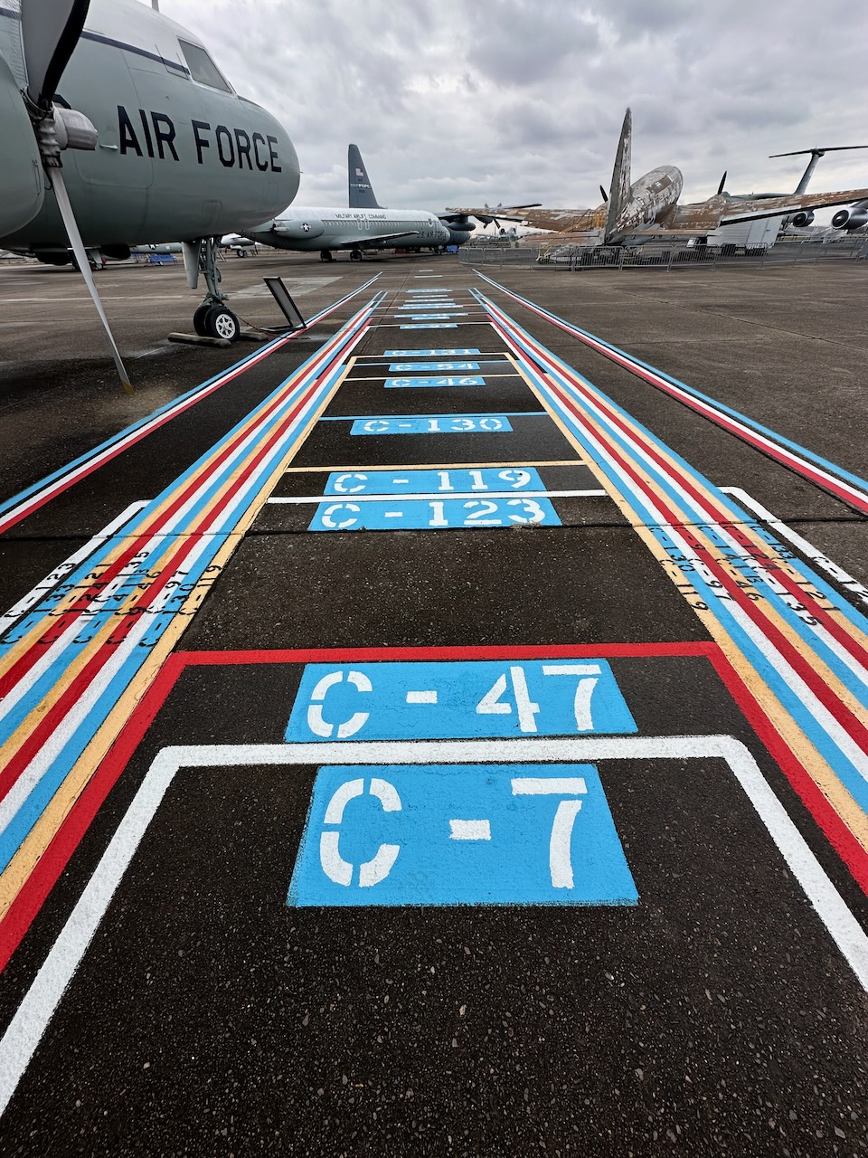 Graphic on tarmac that shows cargo bay size of varying planes.
