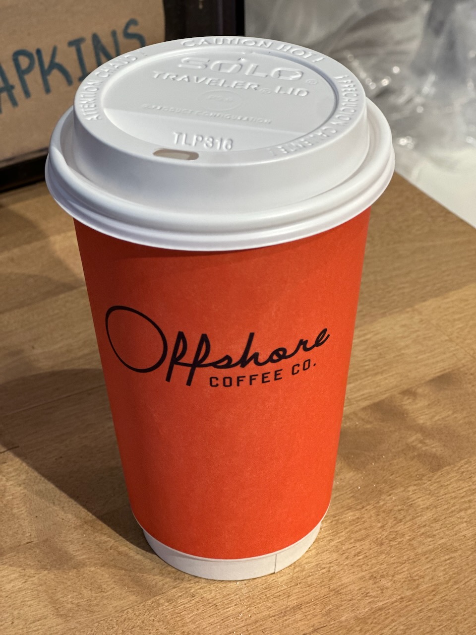 Coffee cup that has words OFFSHORE COFFEE CO written on side.