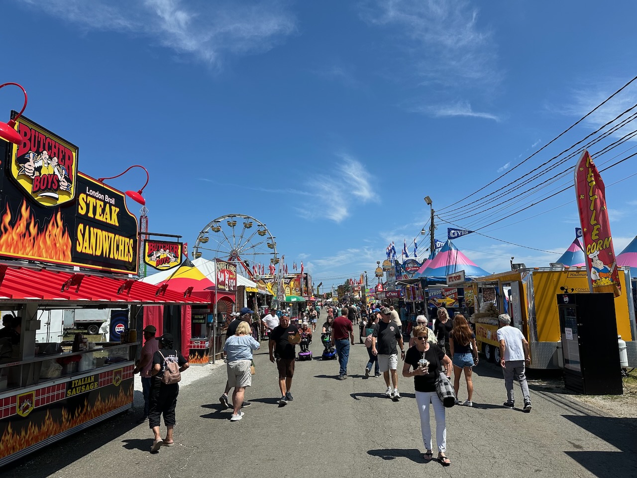 Main thoroughfare at New Jersey state fair, with food stalls on either side.