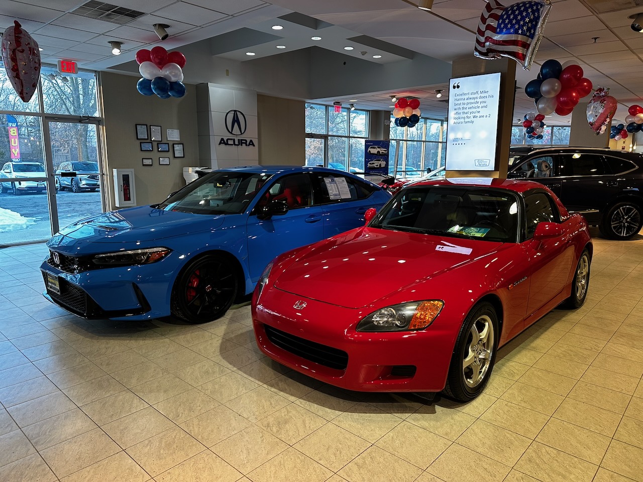 Red Honda S2000 and blue Honda Civic Type R on showroom floor of dealership