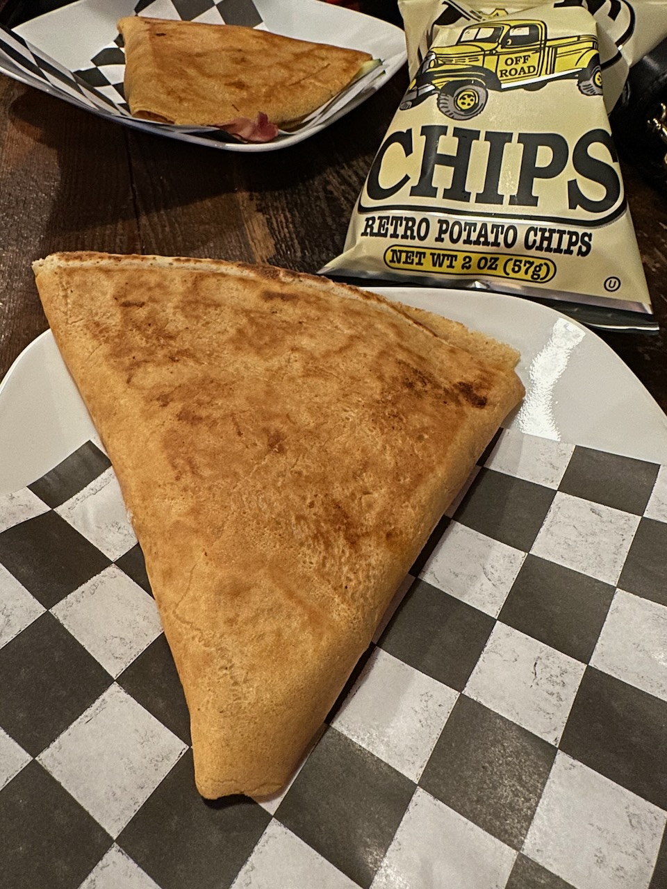 Bahn Mi Crepe on plate, with bag of chips in background.
