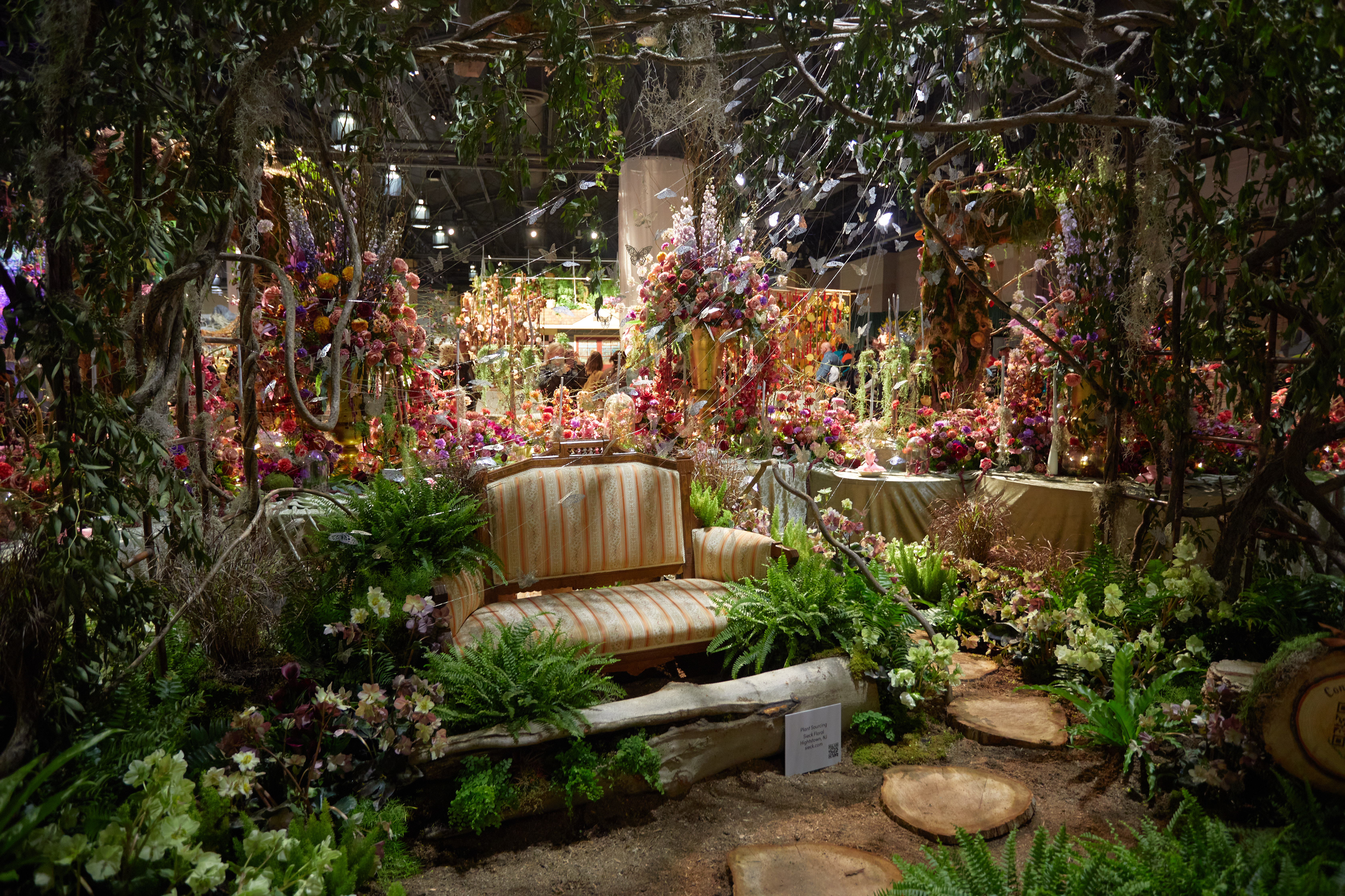 Forest exhibit with loveseat surrounded by vines and shrubbery.