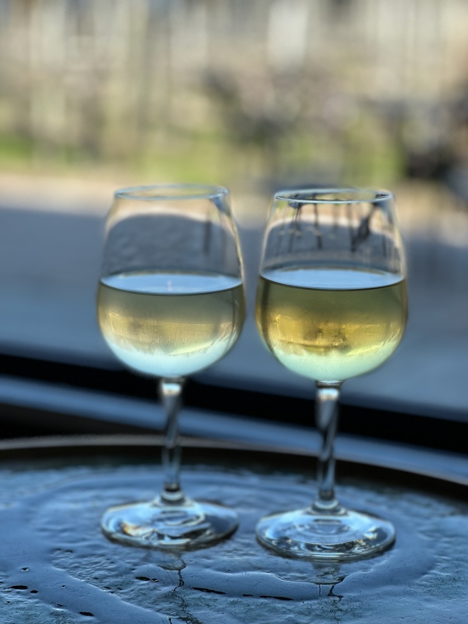 Two glasses of white wine on table.