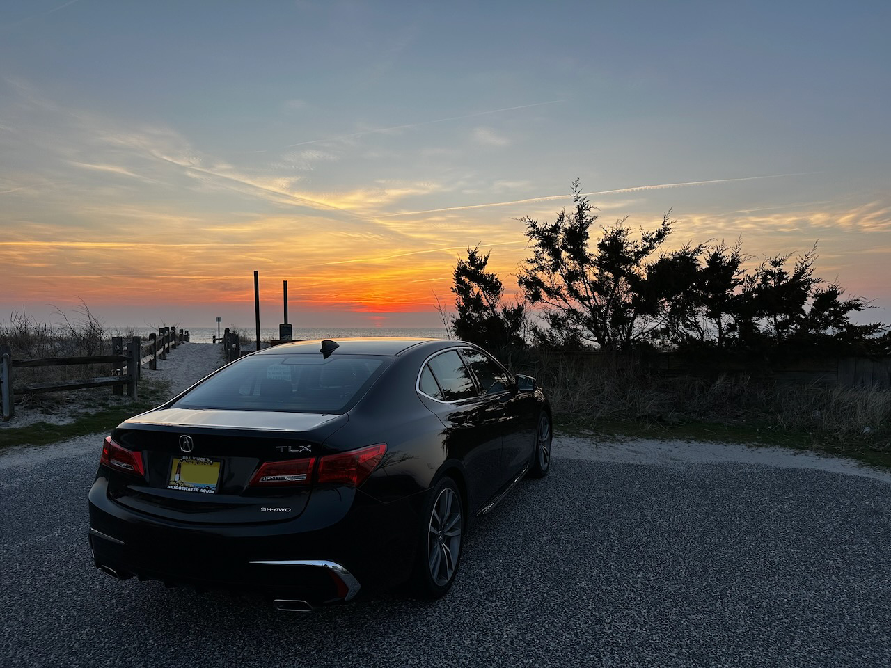 2020 Acura TLX parked in front of beach at sunset.