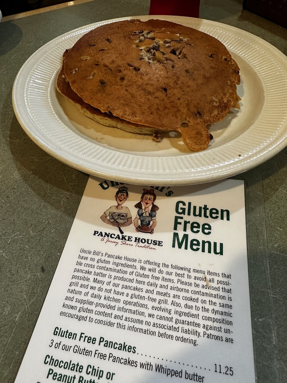 Gluten free pecan pancakes on white plate, with gluten free menu in foreground.