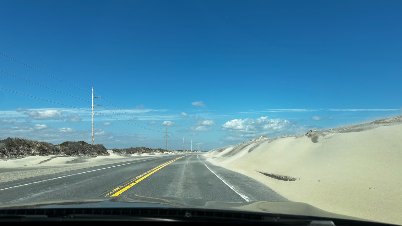 View of North Carolina Highway 12 with dunes on either side of road.