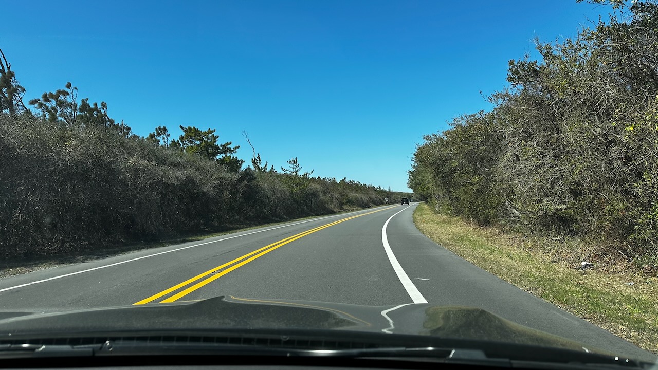 View of Highway 12 as it curves. The sky is blue and sunny.
