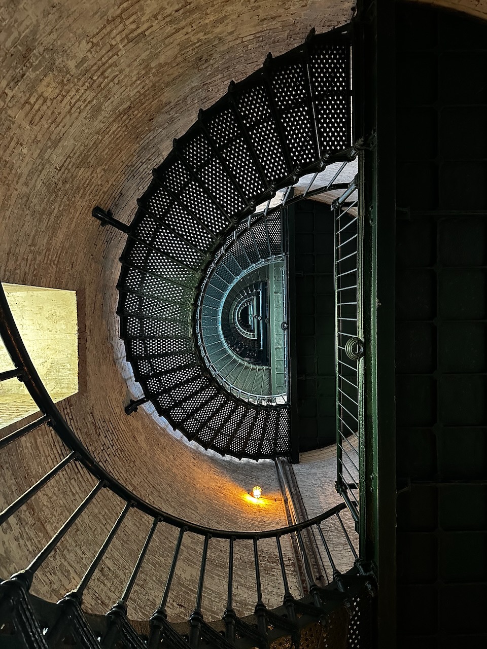 View of spiral staircase within lighthouse looking upward.