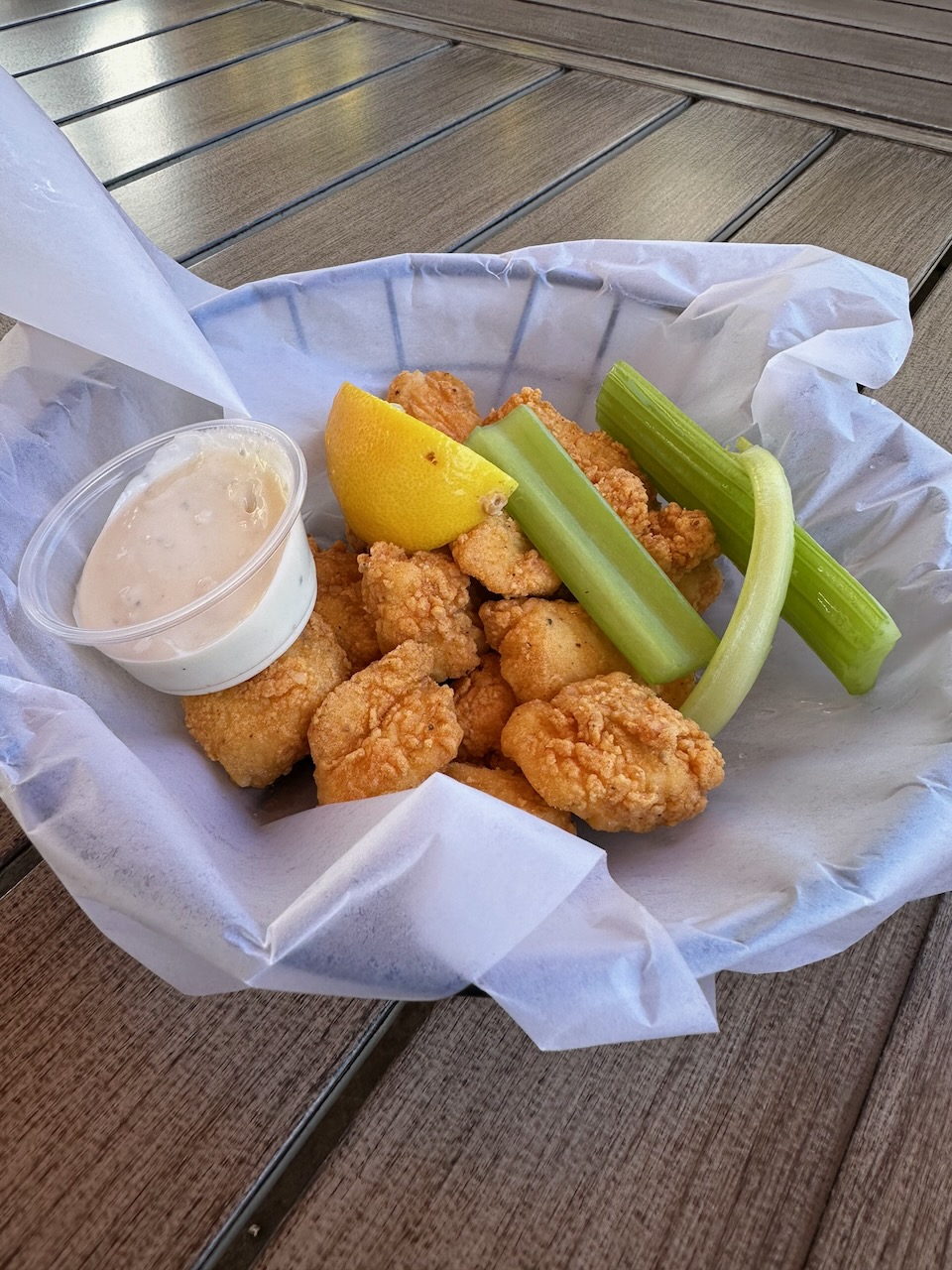 Maki bites, with celery and cup of ranch dressing, in basket.
