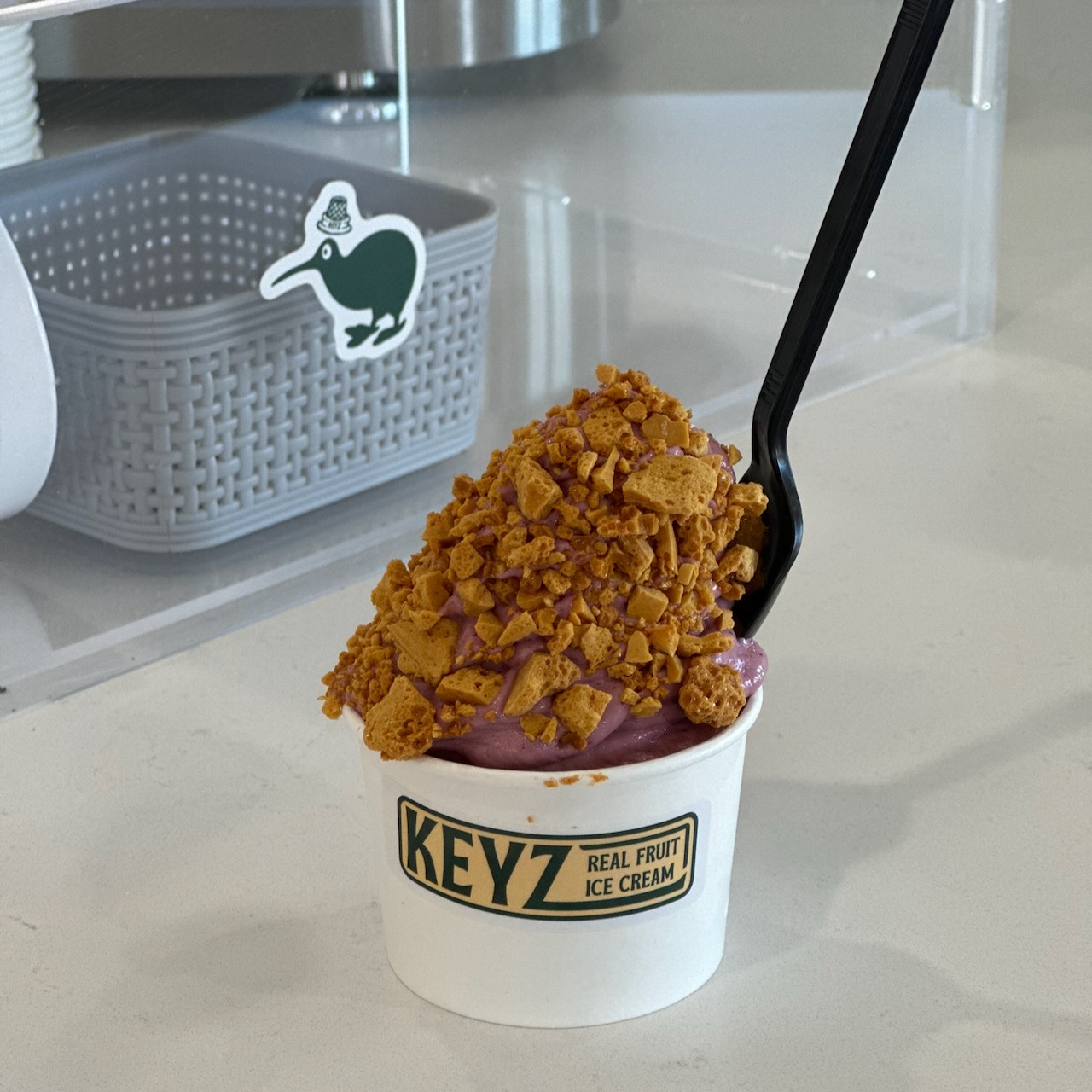 Cup of dairy-free vanilla ice cream with kookaberry and Hokey Pokey.