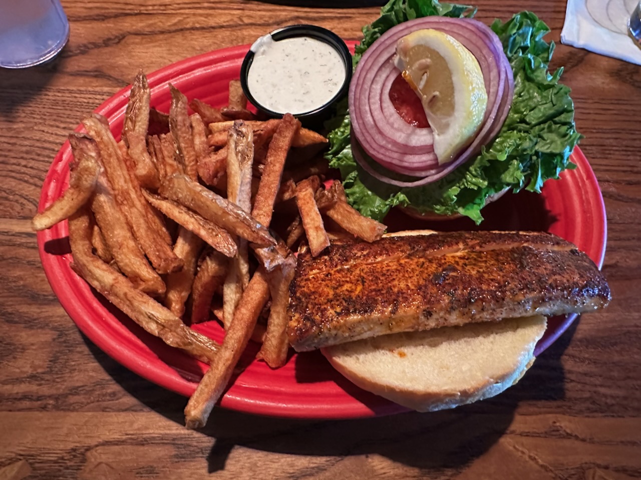Blackened tuna sandwich and French fries on plate.