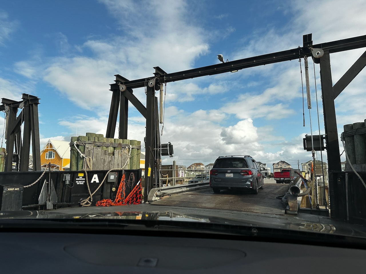 View of ramp to dock of ferry, with vehicles departing.