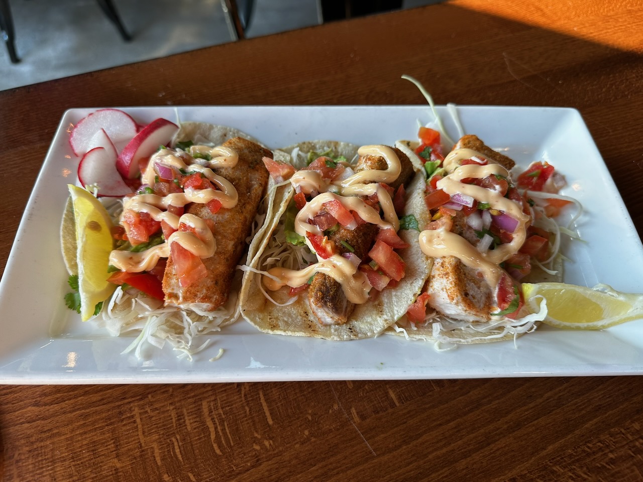 Blackened mahi mahi tacos on white plate.