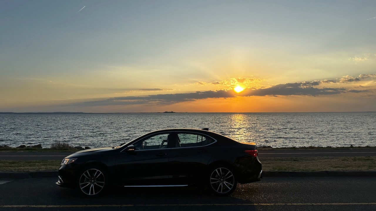 2020 Acura TLX parked in front of sunset over Sandy Hook Bay.