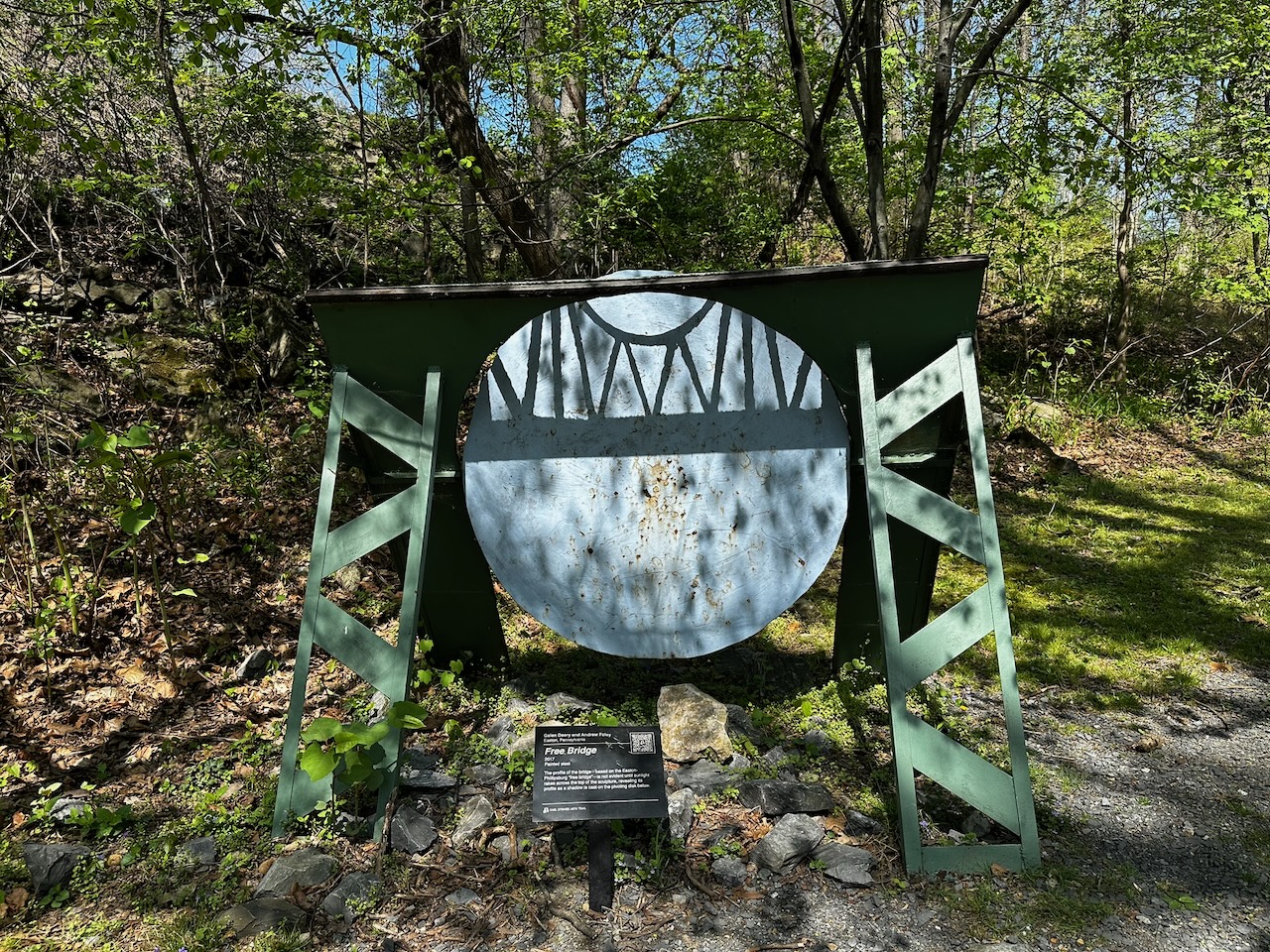 Free Bridge installation, made of metal to look similar to bridge in Easton. Trees are in background.