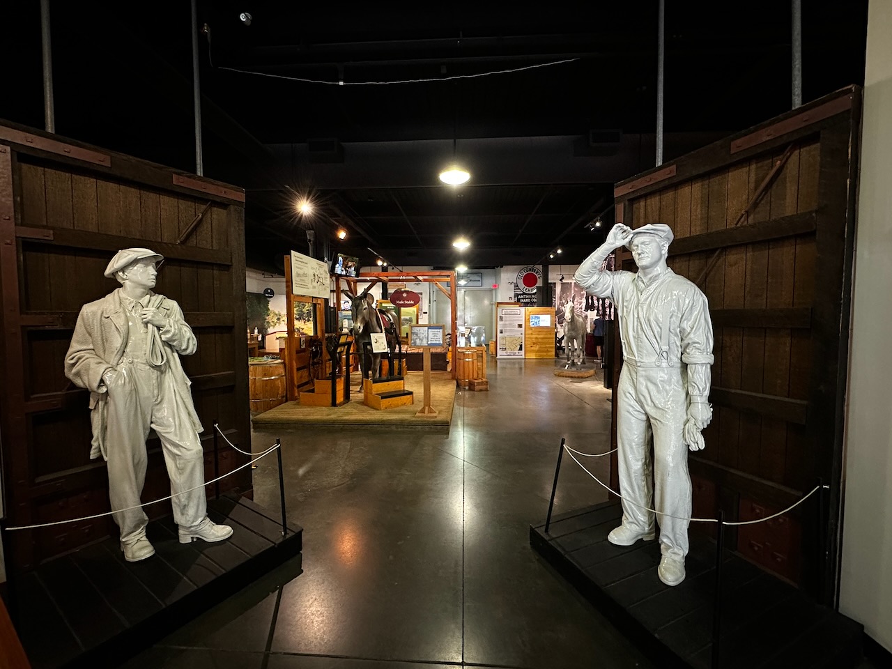 Two statues of canal workers in front of entrance doors.