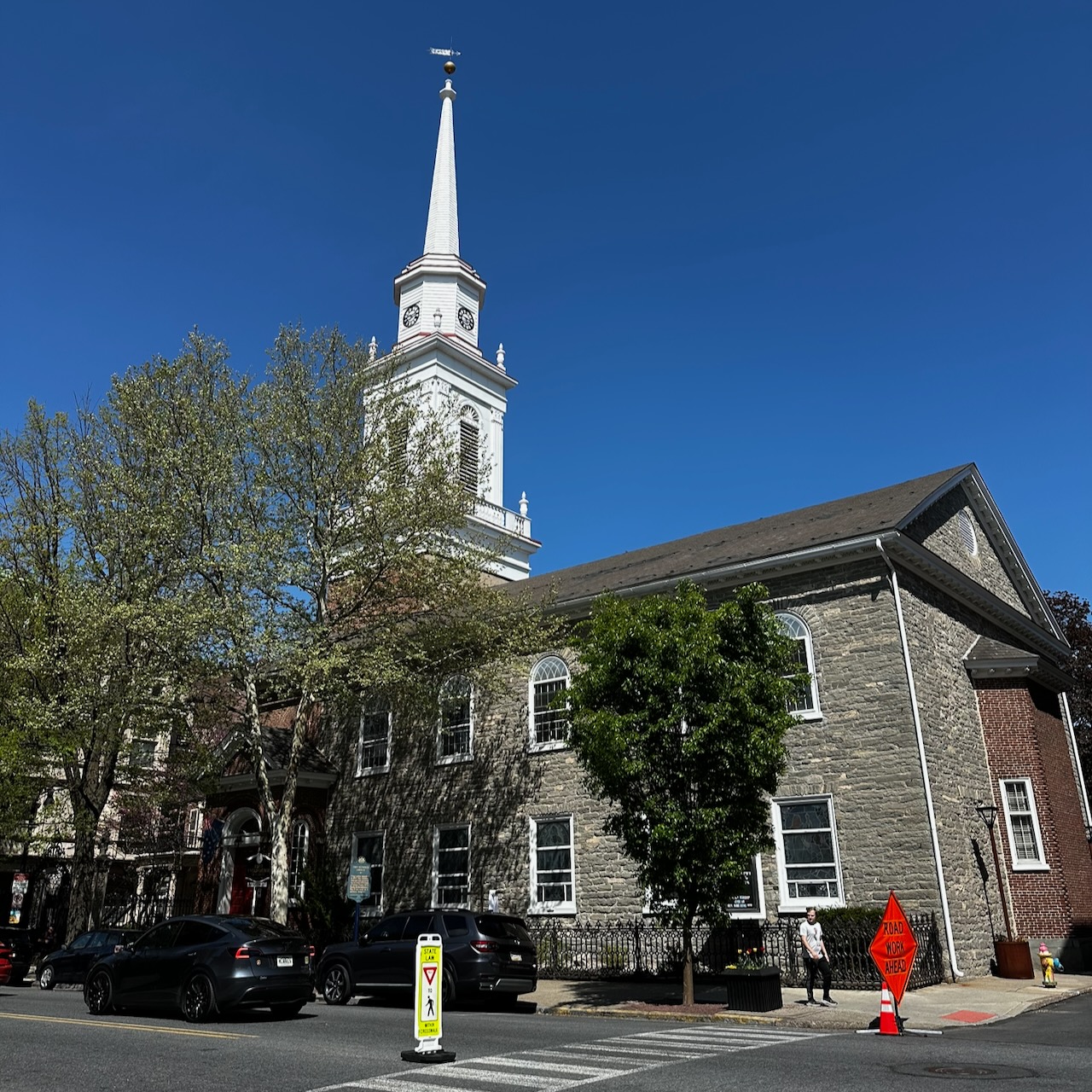 Exterior of Old Reformed Church, with towering white spire emanating from middle of church.